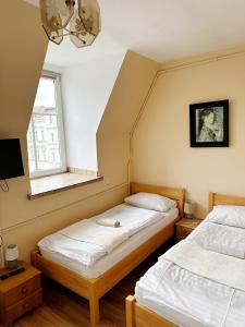 two beds in a room with a window at Hotel Lubavia in Lubawka