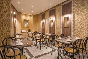 a restaurant with tables and chairs in a room at Terminus Orléans Paris in Paris