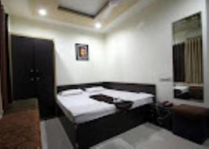 Habitación con 2 camas y espejo. en Hotel Royal Inn Tripura en Rādhākishorepur