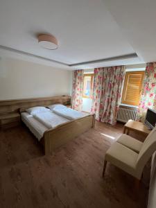 維皮泰諾的住宿－goldenes kreuz，一间卧室配有一张床和一把椅子