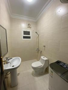 a bathroom with a white toilet and a sink at نايتس للوحدات المفروشة in Tabuk