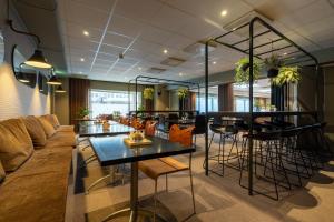 a living room with a couch and tables and chairs at Spar Hotel Gårda in Gothenburg