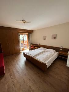 a bedroom with a large bed and a wooden floor at goldenes kreuz in Vipiteno