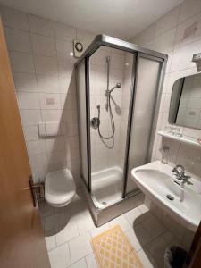 a bathroom with a shower and a toilet and a sink at goldenes kreuz in Vipiteno