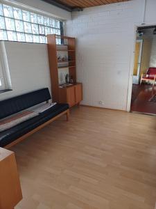 een grote kamer met een bank en een houten vloer bij Majoitus Yli-Torkko in Seinäjoki