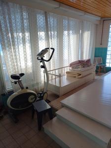a room with a room with a treadmill and a bed at Majoitus Yli-Torkko in Seinäjoki