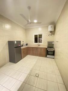 a large kitchen with a refrigerator and a stove at نايتس للوحدات المفروشة in Tabuk