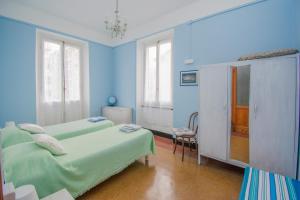 a blue room with two beds and a chair at Cà da Nalda in Lavagna