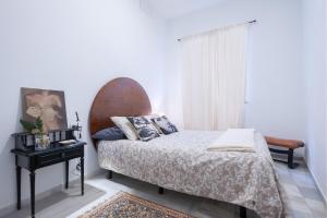 a bedroom with a bed and a table and a window at Santo Domingo 10 in Seville
