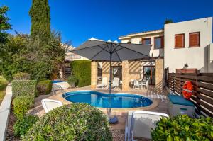 une maison avec une piscine entourée d'un parasol dans l'établissement 2 bedroom Villa Kornos with private pool and golf views, Aphrodite Hills Resort, à Kouklia