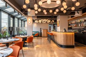 ein Restaurant mit Tischen und Stühlen und einer Bar in der Unterkunft Aston Hotel Riga in Riga