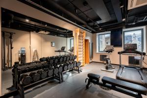 a gym with rows of dumbbells in a room at Aston Hotel Riga in Rīga