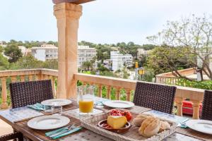 einen Tisch mit einem Teller Essen auf dem Balkon in der Unterkunft Villa Torre Mar with swimming pool and 100m to the beach in Cala Santanyi