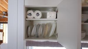 a cupboard filled with plates and utensils at 民泊 山の家 フィンランド式サウナ-要予約-付き一軒家 in Iwamizawa