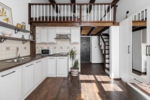 a kitchen with white cabinets and a staircase at InshiApartments on Slovatskoho str in Lviv