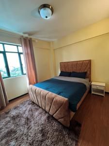 een slaapkamer met een bed en een groot raam bij Furnished 2 bedroom apartment in Kilimani in Nairobi