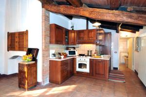uma cozinha com armários de madeira e um forno com placa de fogão em Villa Giara - Piscina vista Lago Trasimeno Umbria em Paciano