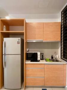 cocina con nevera blanca y armarios de madera en Mediterranean Style Suite @ Austin, JB #06, en Johor Bahru