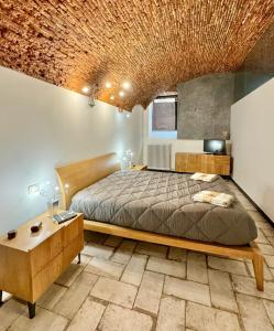 a bedroom with a bed and a brick ceiling at Hostdomus - Perla nel Borgo in Borgio Verezzi