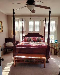 a bedroom with a large bed with a wooden canopy at Fairfax Bed and Breakfast in Franklin