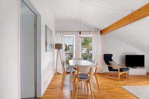 sala de estar con mesa, sillas y TV en Blaustein Loft, en Blaustein