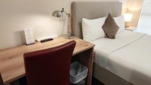Ellard Bed & Breakfast في بيرث: غرفة نوم مع سرير ومكتب مع مصباح