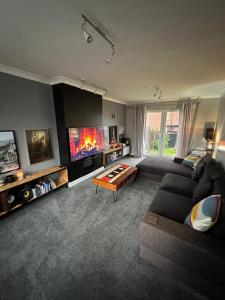 uma sala de estar com um sofá e uma televisão de ecrã plano em Music lovers house em Morley