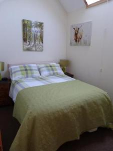 um quarto com uma cama e duas fotografias na parede em Broomhead Cottages em Dufftown