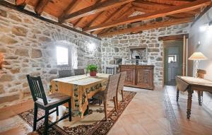 ein Esszimmer mit einem Tisch und einer Steinmauer in der Unterkunft Awesome Apartment In Bordezac With Kitchen in Bordezac