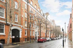 a red car parked on a street next to buildings at Elegant 1BR Apartment Near Central London in London