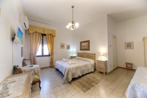 1 dormitorio grande con 2 camas y mesa en B&B Antica Dimora, en Olbia