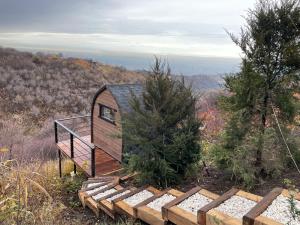 a cabin on the side of a hill with a deck at SweeDom Shale in Almaty