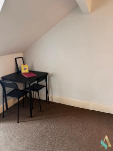 a black table with two chairs in a room at Milton Road Flat 3 TSAC in Hartlepool