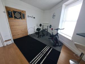 a room with a gym with exercise equipment and a window at The Old Post Office in Morriston