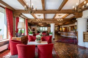 デーブリアッハにあるFamiliengut Hotel Burgstallerの赤い椅子とテーブルが備わるホテルロビー