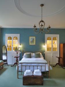 a bedroom with a bed and a chandelier at The Hall in Bradford on Avon