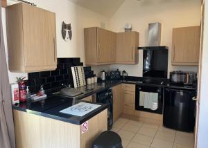 a kitchen with wooden cabinets and a black appliances at Broomhead Cottages in Dufftown