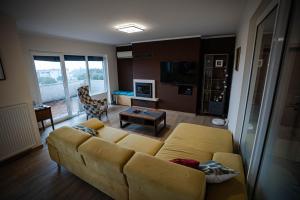 a living room with a yellow couch and a table at Olive Garden Apartment in Plovanija