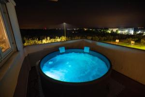 a jacuzzi tub on a balcony at night at Olive Garden Apartment in Plovanija