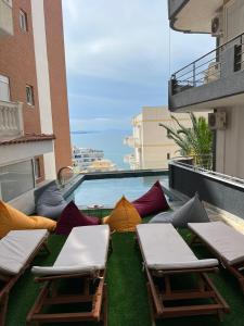 萨兰达Ansi Paradiso Apartaments的大楼内的阳台配有草坪椅和遮阳伞