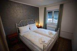 a bedroom with a white bed and a window at Olive Garden Apartment in Plovanija +24 photos