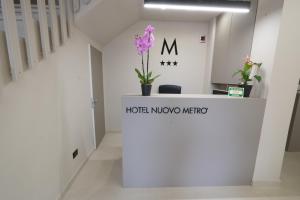 una stanza con bancone e fiori viola di Hotel Nuovo Metrò a Milano