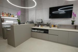 a kitchen with white cabinets and a tv on the wall at Hotel Nuovo Metrò in Milan