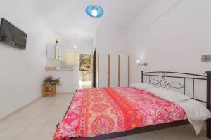 sypialnia z dużym łóżkiem i czerwonym kocem w obiekcie Ruassi Studios w mieście Ammoudi