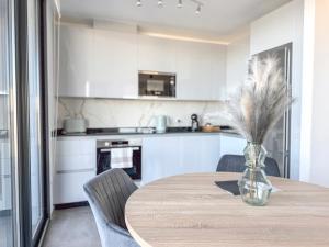 ジブラルタルにあるE1 Suites & Spa aparthotel style - Gym & Spaのキッチン(テーブル、羽毛の花瓶付)