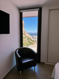 een zwarte stoel in een kamer met een groot raam bij E1 Suites & Spa aparthotel style - Gym & Spa in Gibraltar