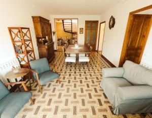 een woonkamer met een bank en een tafel en stoelen bij Cal Comorera in Masoteras