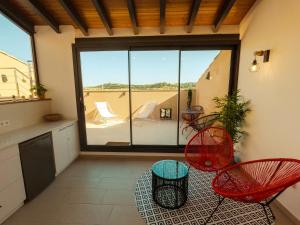 Cal Comorera في Masoteras: غرفة بها كرسيين حمر وشرفة