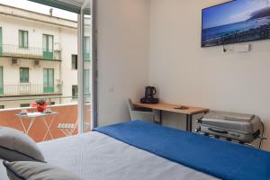 a bedroom with a bed and a tv on the wall at Charming Rooms Amalfi Coast in Maiori