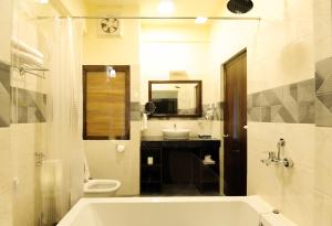 a bathroom with a tub and a toilet and a sink at Eutsholing Boutique Hotel in Thimphu